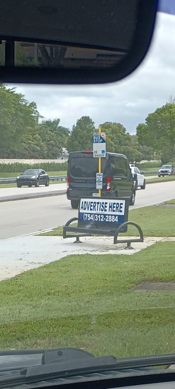 Bus bench on Broward Boulevard showing Advertise Here phone number traced to Gold Coast Advertising