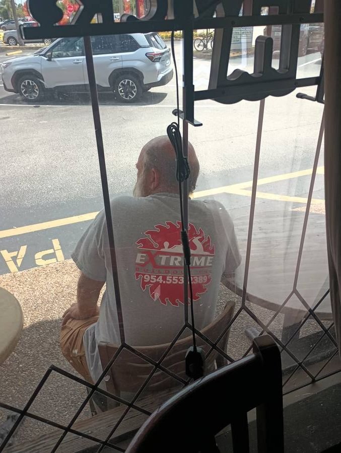Extreme Building Inc employee t-shirt spotted through restaurant window